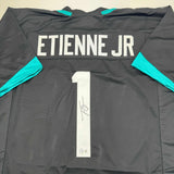 Autographed/Signed Travis Etienne Jr. Jacksonville Black Jersey Beckett BAS COA