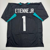 Autographed/Signed Travis Etienne Jr. Jacksonville Black Jersey Beckett BAS COA